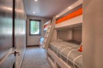 The downstairs bunk room is perfect for kids and adults. Each bunk is built into the wall, with outlets and storage space.